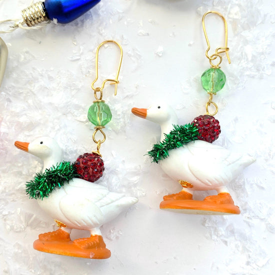 Miniature duck earrings with little white ducks adorned with green Christmas wreaths and red rhinestone beads. Cute Christmas earrings for women.