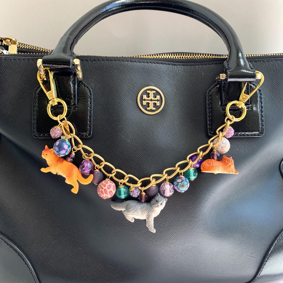 Cat bag charm with cat charms and a mix of purple and green beads on a gold chain. Cute bag chains for handbags. Purple bag cham.