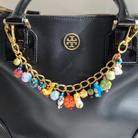 Tiny lampworked glass animals and lampworked floral beads hanging on a gold bag chain with trigger clasps on either end. Cute colorful bag chain for handbags.