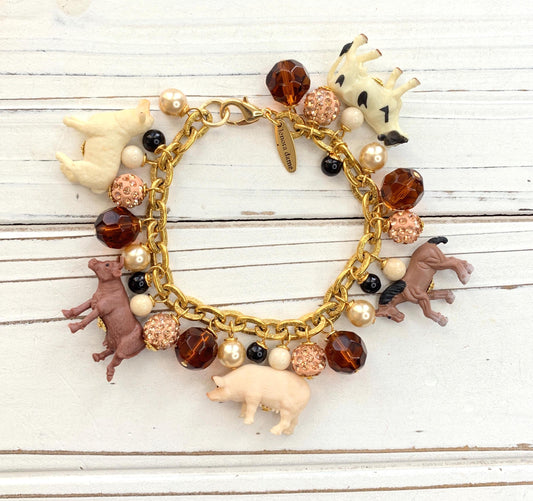 Gold chain charm bracelet with farm animal charms, pearls, peach rhinestone beads and brown faceted beads.