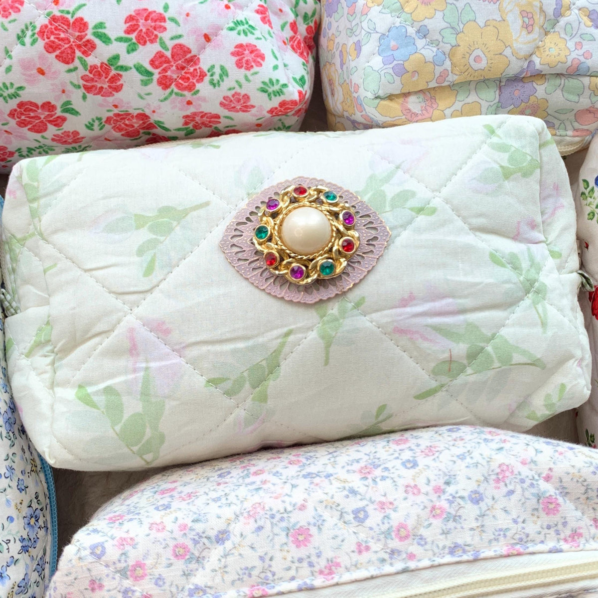 Light green with pink roses floral cotton quilted makeup bag embellished with a round pearl and rhinestone brooch. Cute makeup bags with zipper. Gifts for mom.